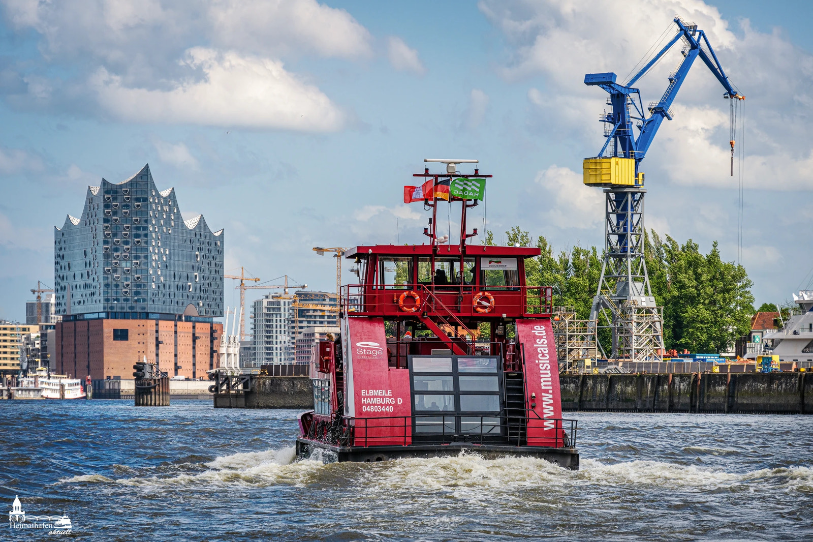 Rote Hafenfähre mit Elbphilharmonie im Hintergrund vom Anleger Fischauktionshalle Altona.