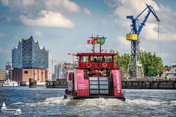 Rote Hafenfähre mit Elbphilharmonie im Hintergrund vom Anleger Fischauktionshalle Altona.