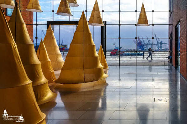 Weihnachtliche Installation mit goldenen, hängenden Bäumen im Holzhafen Hamburg mit Blick auf den Hafen und Kräne