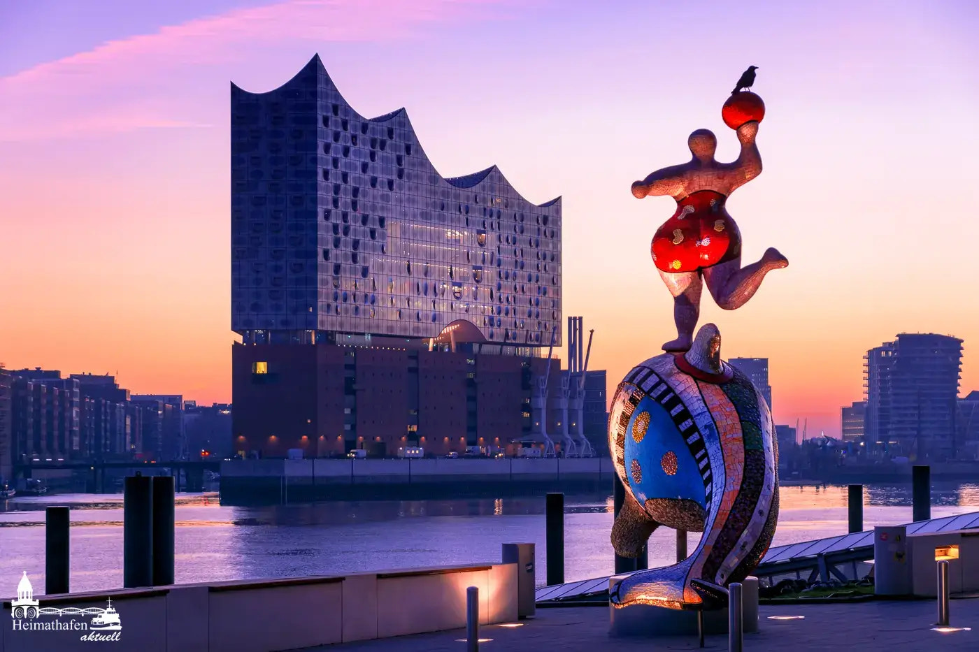Elbphilharmonie bei Sonnenaufgang mit bunter Skulptur im Vordergrund