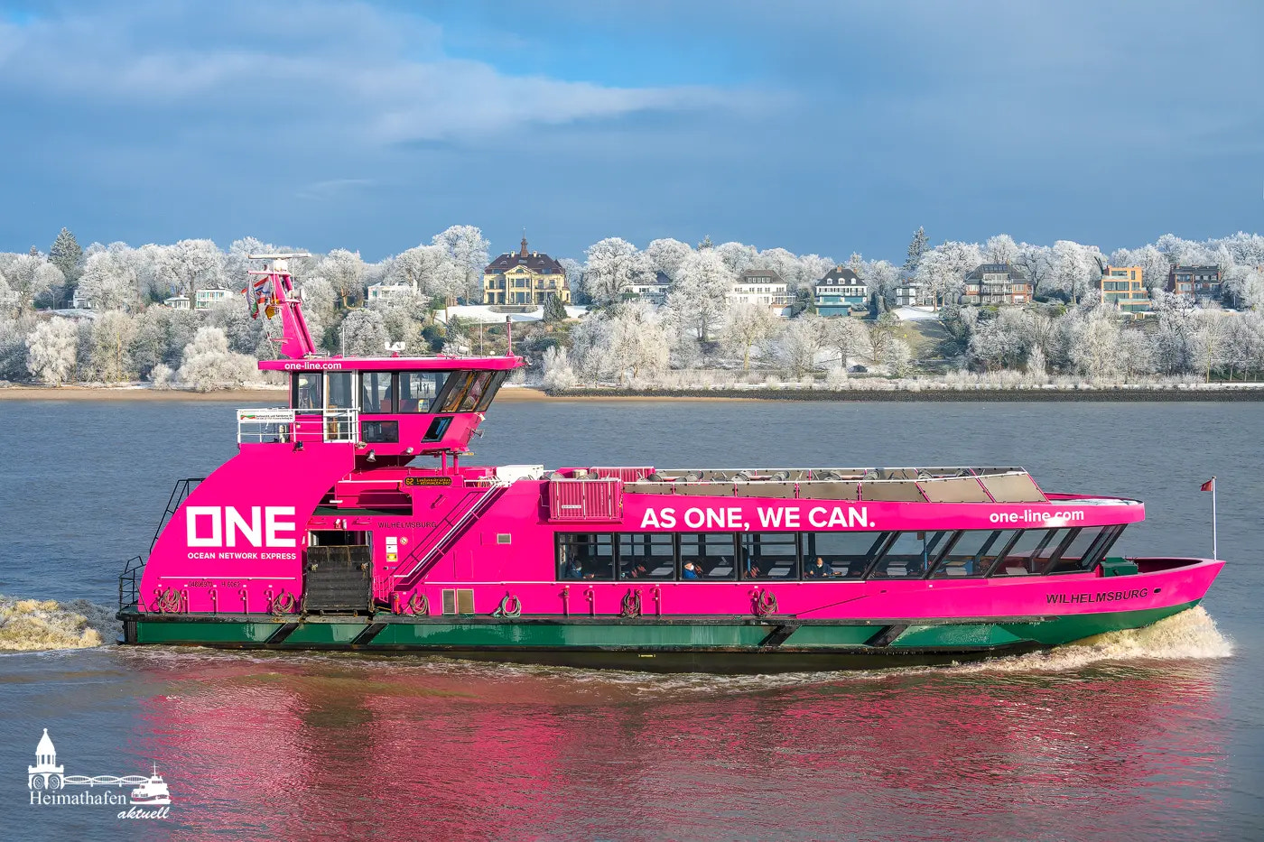 Pinkfarbene HADAG-Hafenfähre Wilhelmsburg im Winter vor verschneiten Elbvororten