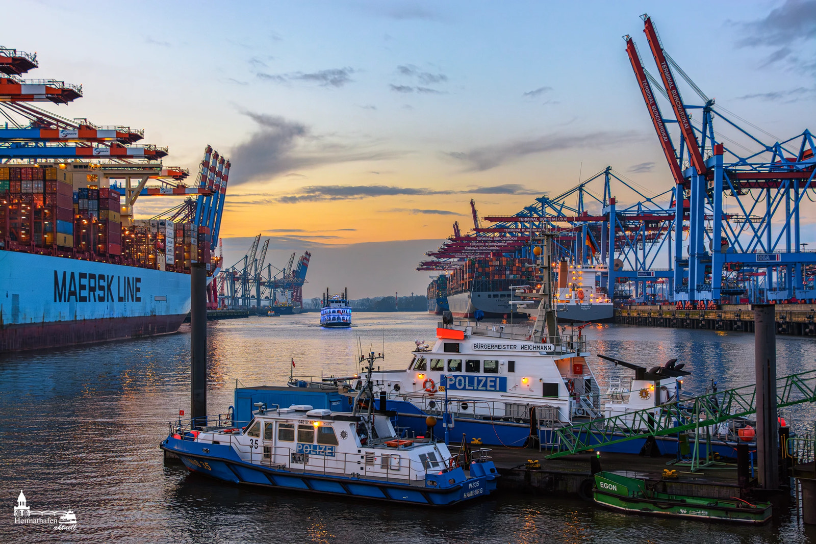 Containerterminal Waltershof mit Polizeibooten Bürgermeister Weichmann und Wasserschutz 35 im Hamburger Hafen bei Sonnenuntergang.