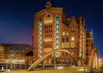 Internationales Maritimes Museum Hamburg bei Nacht mit beleuchtetem Backsteingebäude und Brücke in der HafenCity