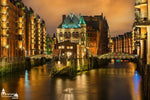 WASSERSCHLOSS in der Hamburger Speicherstadt bei Sonnenuntergang mit goldener Beleuchtung und Spiegelung im Wasser